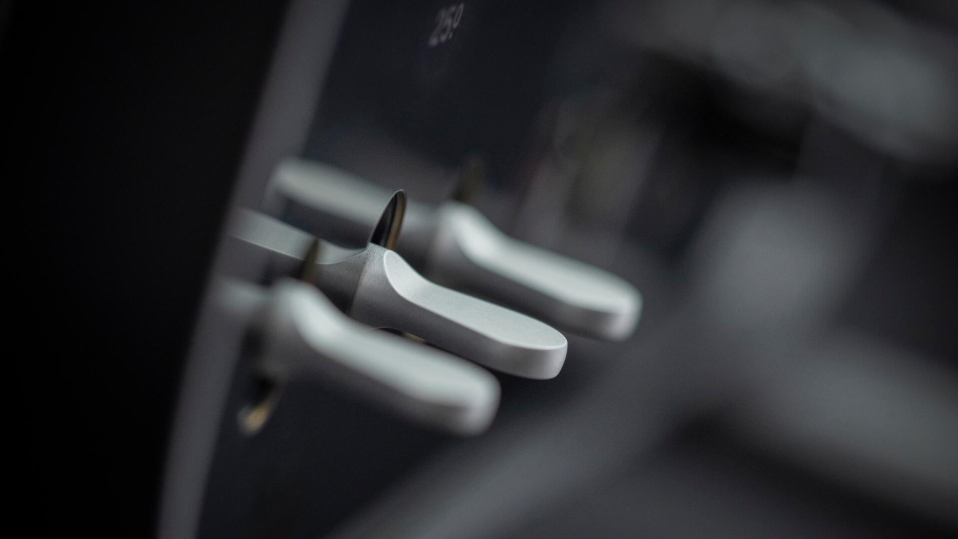 Close-up of brushed aluminum paddle shifters and interior switches in a Ferrari Luce, high-contrast detail — 4K Ultra HD PC desktop wallpaper and background.