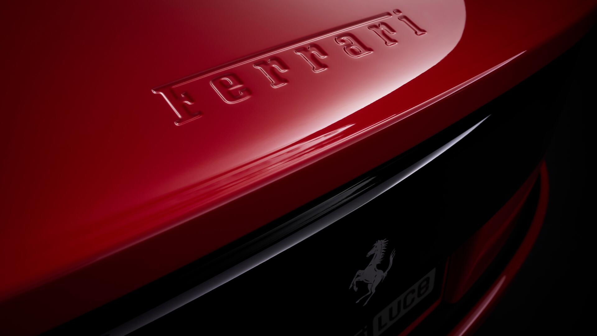 Close-up of red Ferrari Luce rear badge and prancing horse emblem with high-gloss finish — 4K Ultra HD PC desktop wallpaper and background showcasing a Ferrari vehicle.