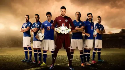 HD desktop wallpaper of Cruz Azul soccer goalkeeper in maroon, holding a ball and standing with teammates in blue kits on a dramatic stadium background.
