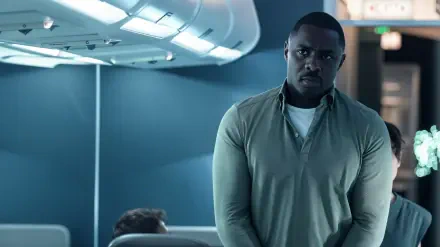 4K Ultra HD PC desktop wallpaper from TV show Hijack: tense airplane cabin scene with a serious passenger standing in the aisle under moody blue lighting.