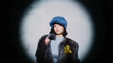 4K Ultra HD PC desktop wallpaper of a model in a blue fur hat and dark fur coat, posed under a soft circular spotlight on a gray backdrop.