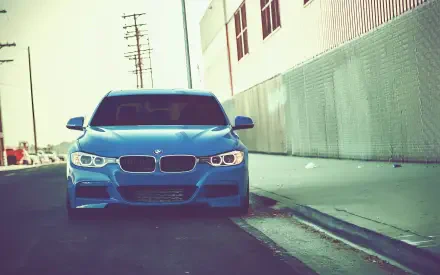 Blue BMW 328i front view parked along an urban curb, high-definition PC desktop wallpaper background.