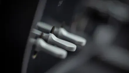 Close-up of brushed aluminum paddle shifters and interior switches in a Ferrari Luce, high-contrast detail — 4K Ultra HD PC desktop wallpaper and background.