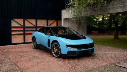 Light blue Ferrari Luce sports vehicle parked outside a modern garage, high-detail 4K Ultra HD PC desktop wallpaper/background.