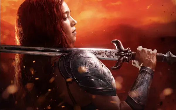 HD PC desktop wallpaper from the Red Sonja movie: red-haired woman warrior in armor gripping a broad sword against a fiery orange sky background.