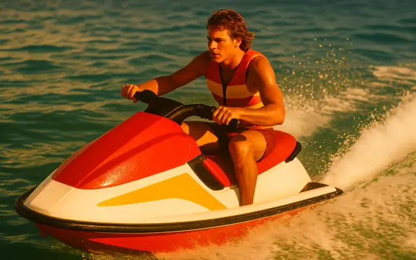 4K Ultra HD PC desktop wallpaper showing a person riding a red-and-white jet ski across sunlit, choppy water.