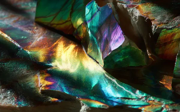 Iridescent close-up of a shimmering folded metallic surface in vivid blues, greens and golds — 4K Ultra HD PC desktop wallpaper and background.
