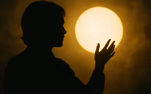 Silhouette of a person reaching toward a glowing sun-like orb against a warm, hazy sky — 4K Ultra HD PC Desktop Wallpaper and Background.