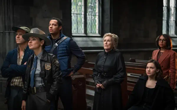 HD PC desktop wallpaper from the movie Wake Up Dead Man: A Knives Out Mystery — an ensemble cast gathered in a shadowed church interior, tense and cinematic background.