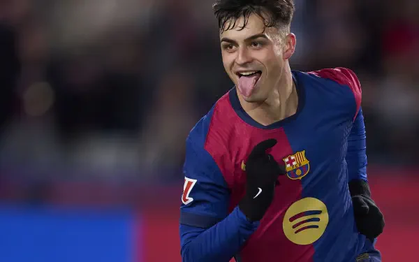HD PC desktop wallpaper of a jubilant FC Barcelona soccer player celebrating on the pitch, wearing club colors and pointing while sticking out his tongue.