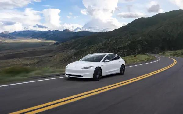 White Tesla Model 3 cruising a winding mountain road, 4K Ultra HD PC desktop wallpaper background.