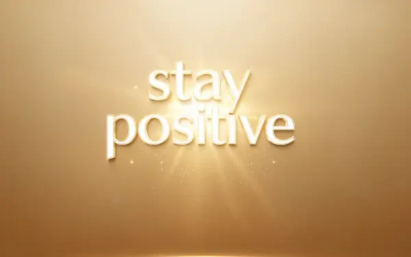 Warm gold 4K Ultra HD PC desktop wallpaper background with radiant sunburst and centered stay positive text.