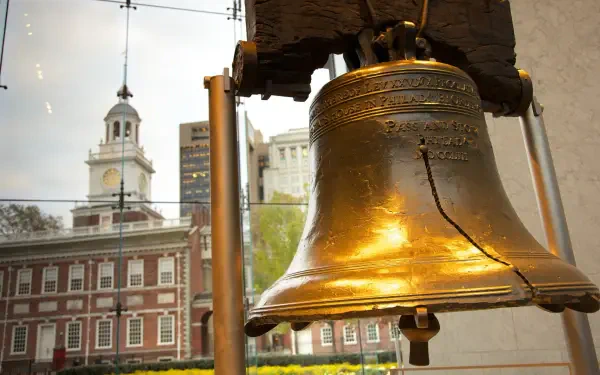 Close-up of the Liberty Bell monument in the United States with Independence Hall visible behind — 2K Quad HD PC desktop wallpaper background.