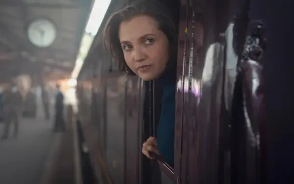 Young woman peering from a train window onto a dim underground platform — 4K Ultra HD PC wallpaper featuring an actress from Agatha Christie's Seven Dials.