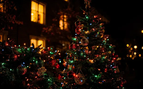 Colorful Christmas tree with multicolored lights and ornaments at night — 4K Ultra HD PC desktop wallpaper/background.