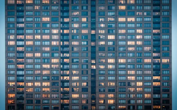 4K Ultra HD PC desktop wallpaper and background: tight grid of illuminated apartment windows on a high-rise facade at dusk, teal tones with warm interior lights.