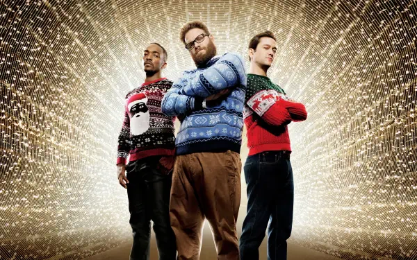 Three men in festive holiday sweaters stand with arms crossed before a radiant golden spark burst — 4K Ultra HD PC Desktop Wallpaper and Background.