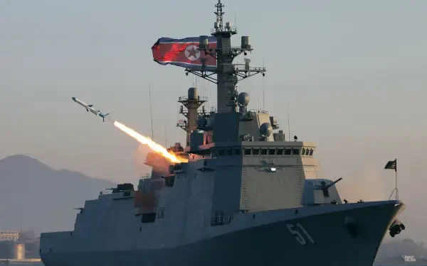 4K Ultra HD PC desktop background of a Choe Hyon-class guided missile destroyer launching a missile at sea; military naval fleet warship framed by distant mountains.