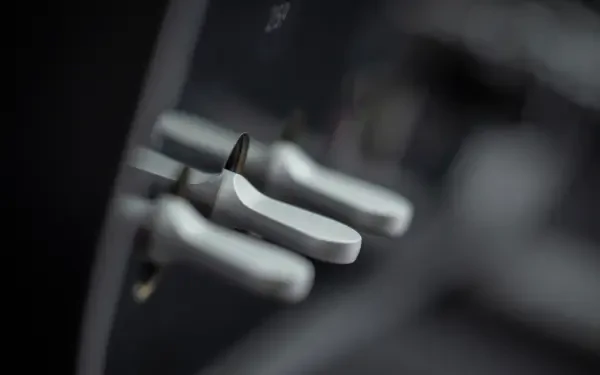 Close-up of brushed aluminum paddle shifters and interior switches in a Ferrari Luce, high-contrast detail — 4K Ultra HD PC desktop wallpaper and background.