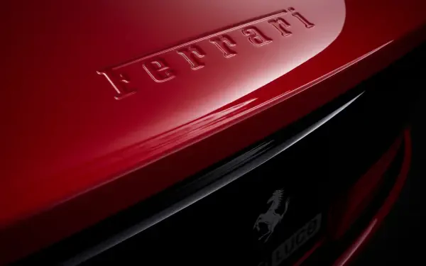 Close-up of red Ferrari Luce rear badge and prancing horse emblem with high-gloss finish — 4K Ultra HD PC desktop wallpaper and background showcasing a Ferrari vehicle.