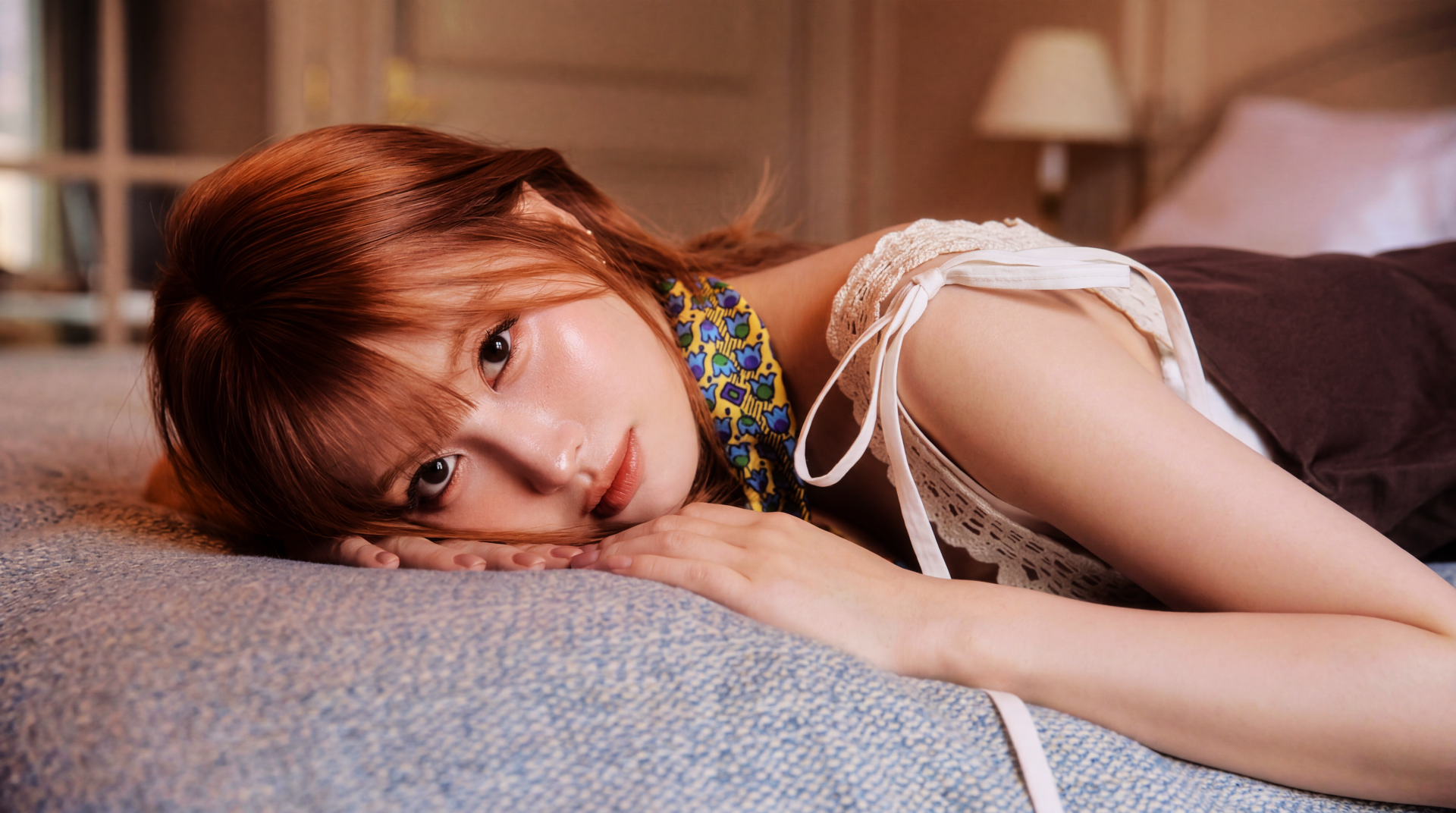 5K Ultra HD PC wallpaper — close-up of a reclining female K-pop singer/model on a bed, warm lighting and a soft, relaxed expression.