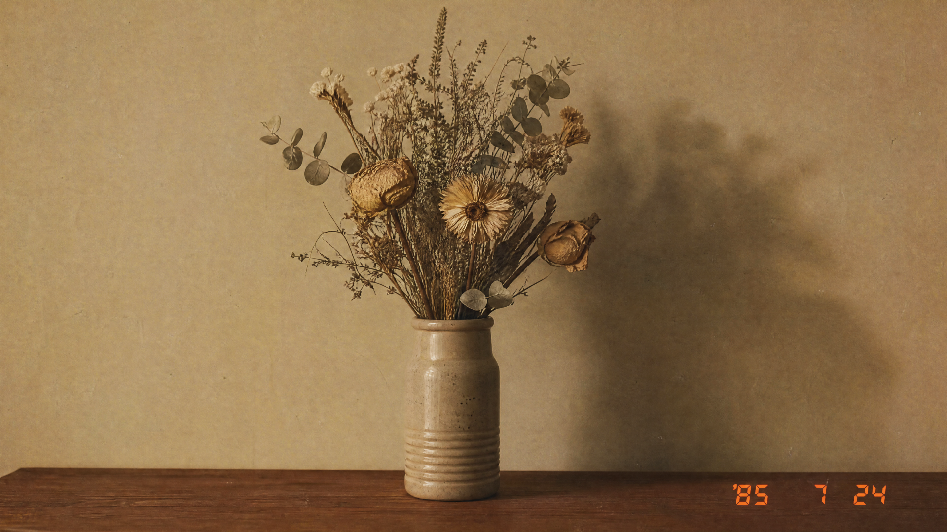 Dried flower bouquet in a cream ceramic vase casting a soft shadow on a warm beige wall - 4K Ultra HD PC desktop wallpaper/background.