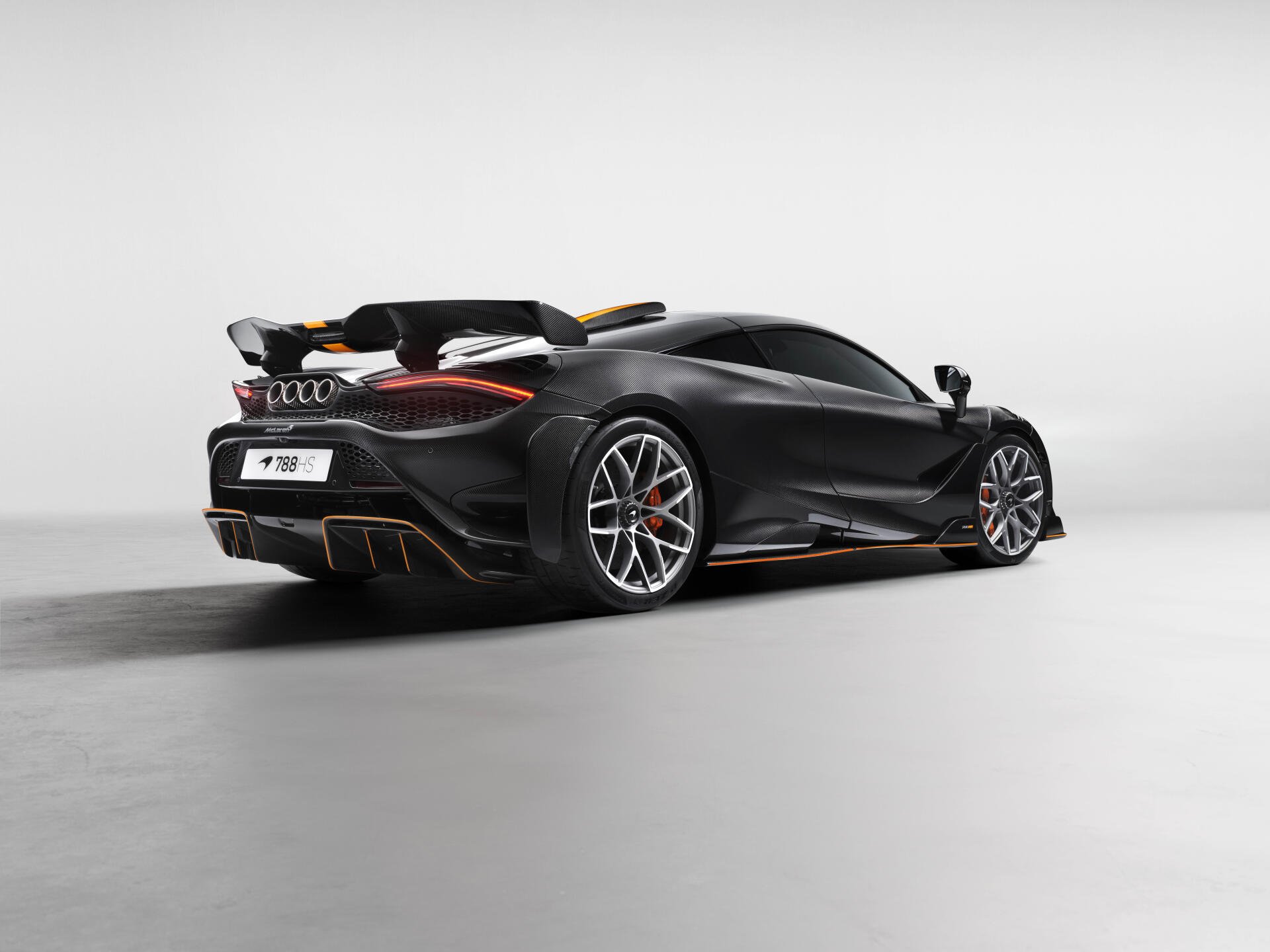 Matte black McLaren 788HS sports car, rear three-quarter view on a minimalist gray studio backdrop — 8K Ultra HD PC desktop wallpaper and background.