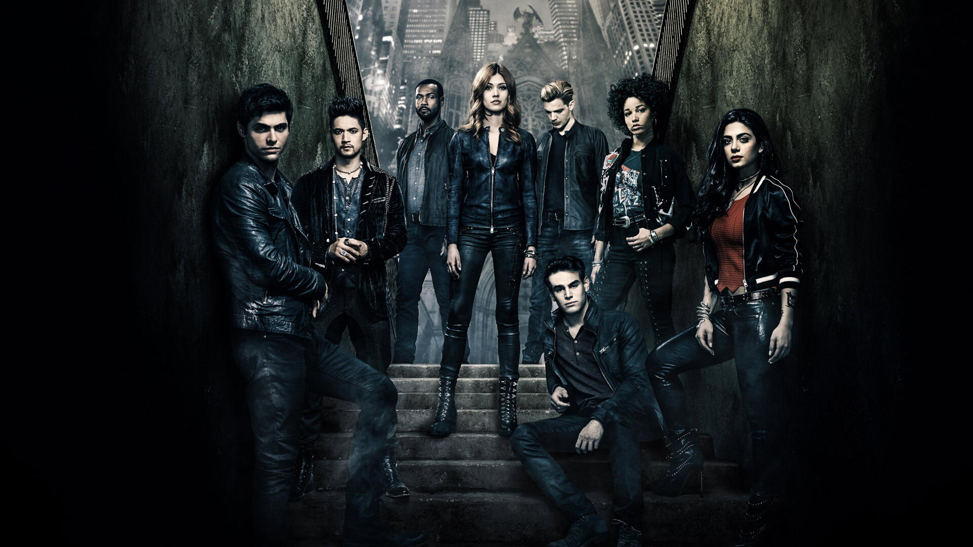 Ensemble of Shadowhunters characters in leather jackets posed on stone steps in a dark, misty gothic alley, moody lighting — 4K Ultra HD PC desktop wallpaper/background.