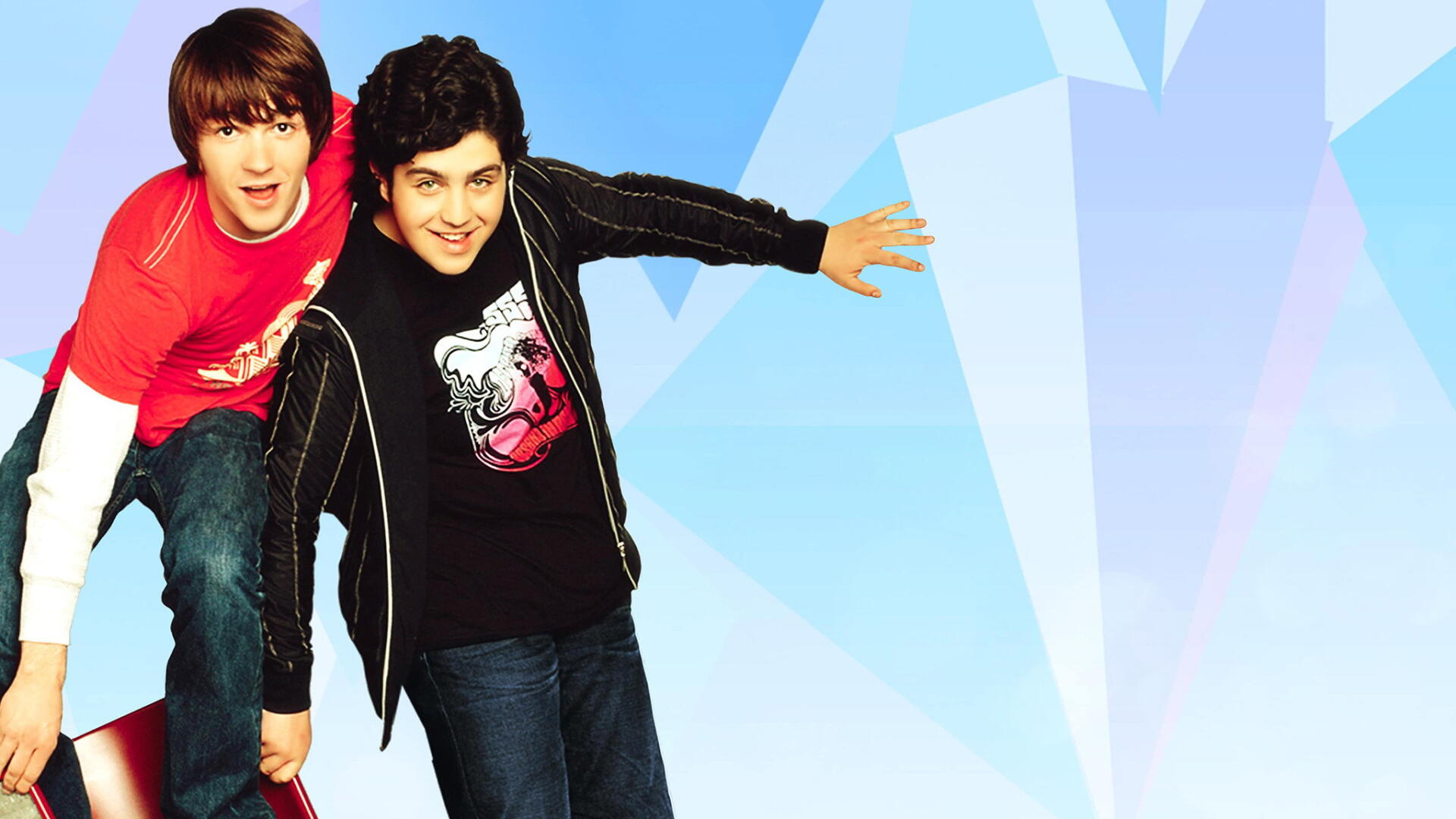 HD PC desktop wallpaper showing two smiling teen sitcom co-stars leaning forward against a pale blue, faceted geometric background.