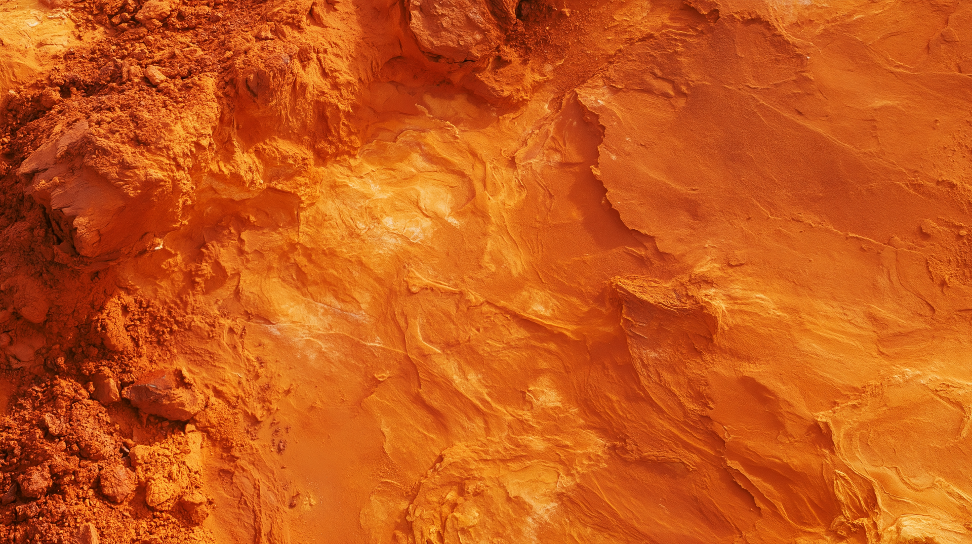 2K Quad HD PC desktop wallpaper showing ocre sandstone rock texture with rich orange-red striations and a rugged, layered surface.