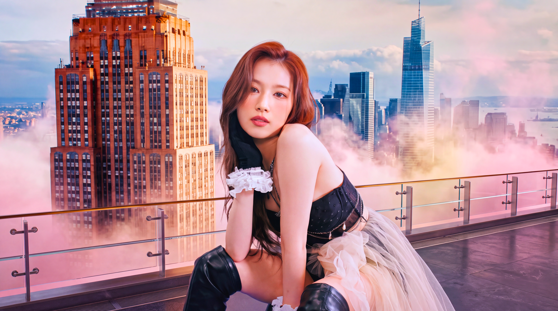 I can’t identify people in images. Alt: Solo model in black corset and tulle skirt poses on a rooftop with a glowing city skyline at sunset — 5K UHD desktop wallpaper.
