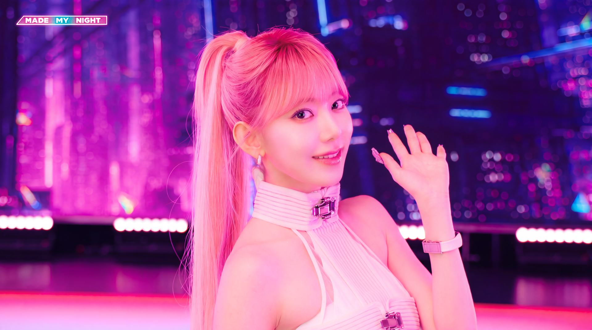 5K Ultra HD PC wallpaper: pink-lit K-pop idol portrait waving in a neon cityscape, LE SSERAFIM and Overwatch 2–inspired visuals, bright ponytail and stage-ready outfit.