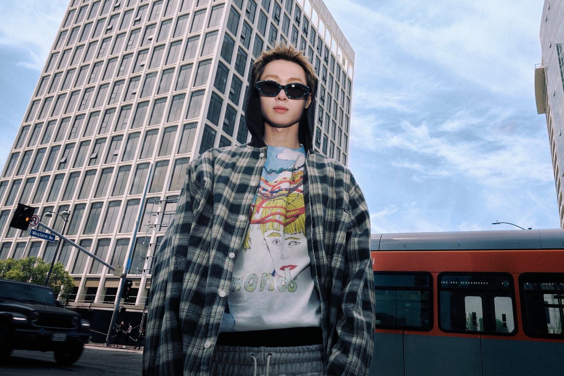 Cortis Color Outside the Lines — fashion portrait of a woman in sunglasses and a plaid jacket against a cityscape and bus; 4K Ultra HD PC desktop wallpaper/background.