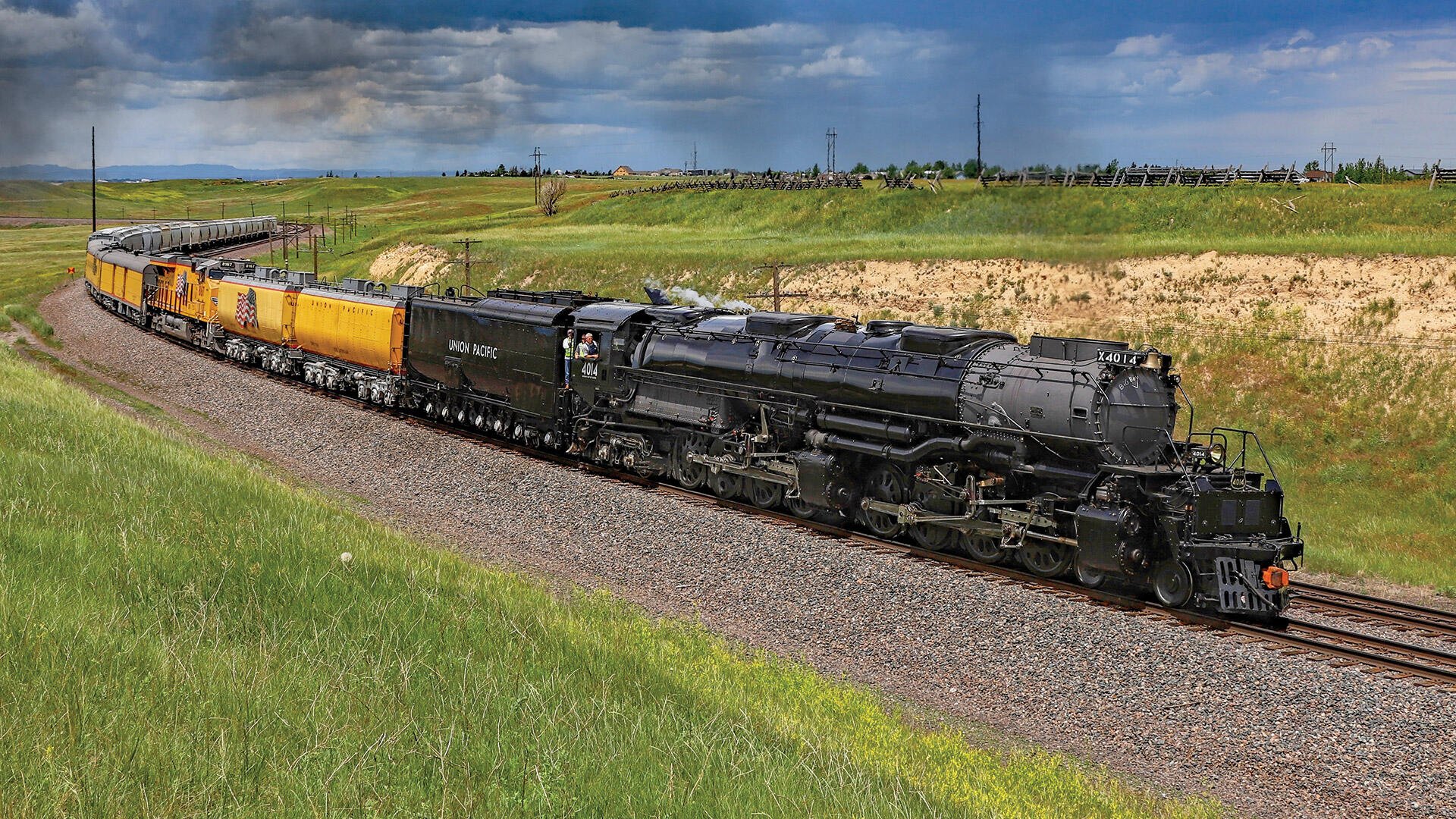 Union Pacific Big Boy 4014 steam locomotive hauling yellow Union Pacific Railroad cars through open countryside, HD desktop wallpaper background.