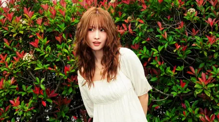 Young woman in a white dress framed by red-green foliage, K-pop/Japanese model aesthetic, 5K Ultra HD PC desktop wallpaper background.