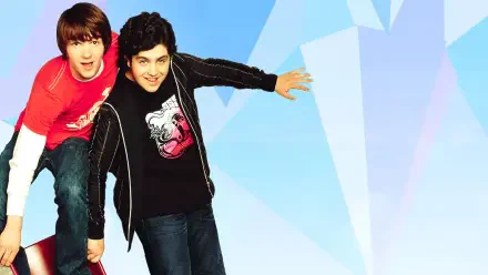 HD PC desktop wallpaper showing two smiling teen sitcom co-stars leaning forward against a pale blue, faceted geometric background.