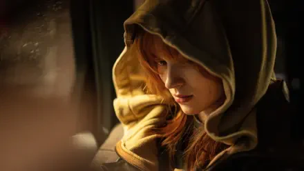 Close-up of a red-haired woman in a hooded jacket, warm cinematic light and pensive expression — Spider-Man: Brand New Day 4K Ultra HD PC Desktop Wallpaper and Background.