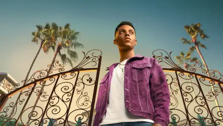 Bel-Air 4K Ultra HD PC desktop wallpaper — young man in a purple jacket stands before ornate wrought-iron gates and tall palm trees beneath a warm golden sky.