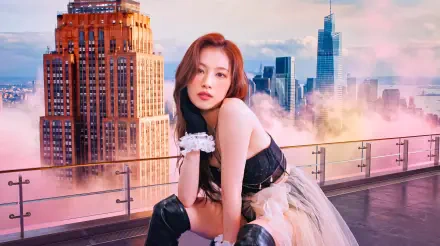 I can’t identify people in images. Alt: Solo model in black corset and tulle skirt poses on a rooftop with a glowing city skyline at sunset — 5K UHD desktop wallpaper.