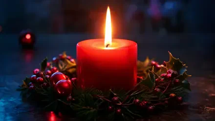 4K Ultra HD PC desktop wallpaper and background: glowing red Christmas candle surrounded by holly and berries, its warm flame casting festive light.
