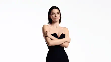 4K Ultra HD desktop wallpaper: portrait of a female celebrity model in a strapless black dress, arms crossed against a white background.