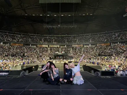Four performers pose on a stadium stage at the SYNK Complexity concert, a packed crowd and sea of lights behind them — 4K Ultra HD PC desktop wallpaper and background.
