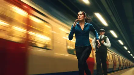 The Runner — 4K Ultra HD PC desktop wallpaper of a determined woman sprinting along a blurred subway platform as a train speeds by, dramatic motion and moody lighting.