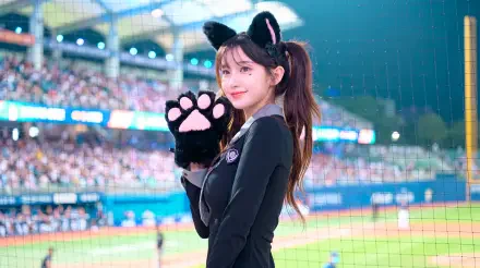 5K Ultra HD desktop wallpaper of a cat-girl cheerleader in a school uniform, wearing cat ears and paw gloves, smiling at a baseball stadium crowd.
