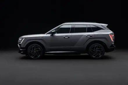 Gray Hyundai Tucson SUV in side profile against a dark studio backdrop, featured in an 8K Ultra HD PC desktop wallpaper.