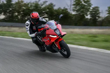 BMW Motorrad F 450 RR motorcycle racer leaning into a turn on a track, featured in an 8K Ultra HD PC desktop wallpaper background.