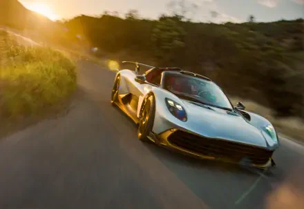 Aston Martin Valhalla Spider supercar on a forest road at golden hour, 8K Ultra HD PC desktop wallpaper and background.