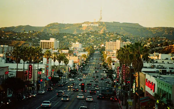 4K Ultra HD PC desktop wallpaper: palm-lined city avenue at dusk leading up to the Hollywood Hills with the white Hollywood sign.
