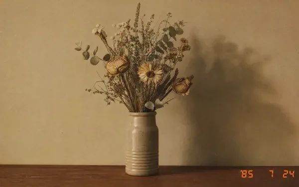 Dried flower bouquet in a cream ceramic vase casting a soft shadow on a warm beige wall - 4K Ultra HD PC desktop wallpaper/background.