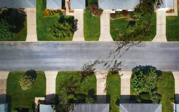 Aerial view titled The End of Oak Street — 4K Ultra HD PC desktop wallpaper showing a suburban street end with tidy lawns, sidewalks, driveways and scattered trees.